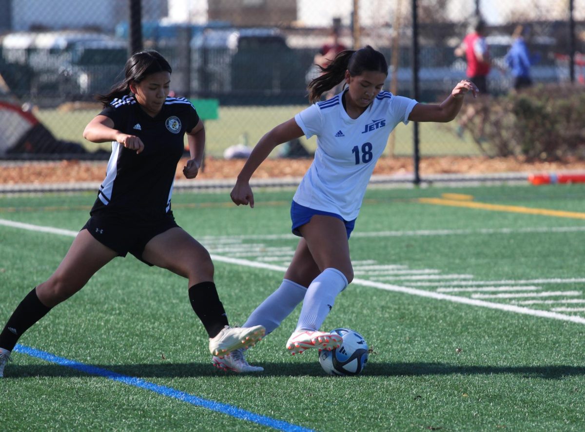 Senior Josie Farris battles for the ball in the first half of Encinal's 2-0 loss to Alameda on January 25, 2024. The match was moved to Estuary Park after AUSD closed both high schools' soccer fields.