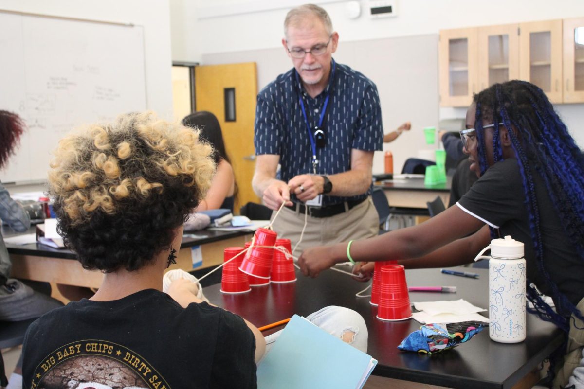 Dr. Boone assists his Biology students in Cup Stacking Team Challenge.